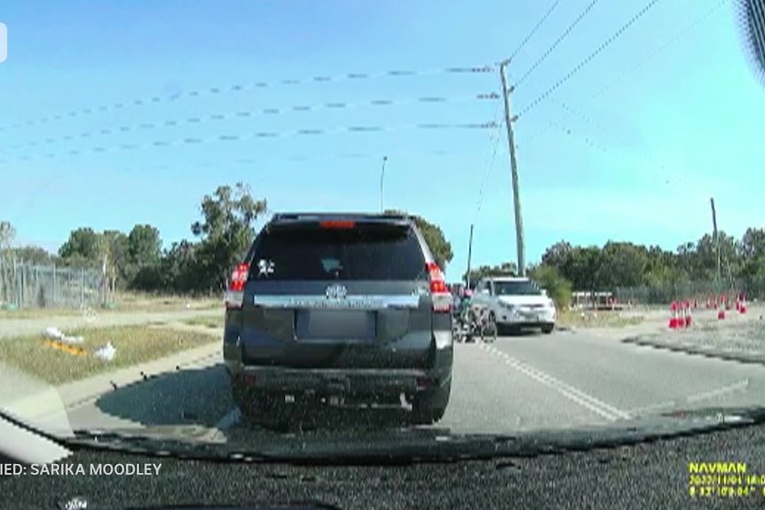 Dash-cam photo of a car nearly running over children on bikes.