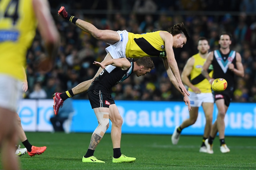 Josh Gibcus is horizontal over Kane Farrell's back as the ball spills out of their reach