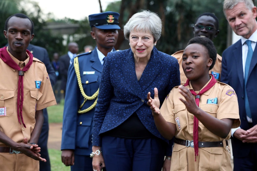 Theresa May listens to a presentation during her visit.