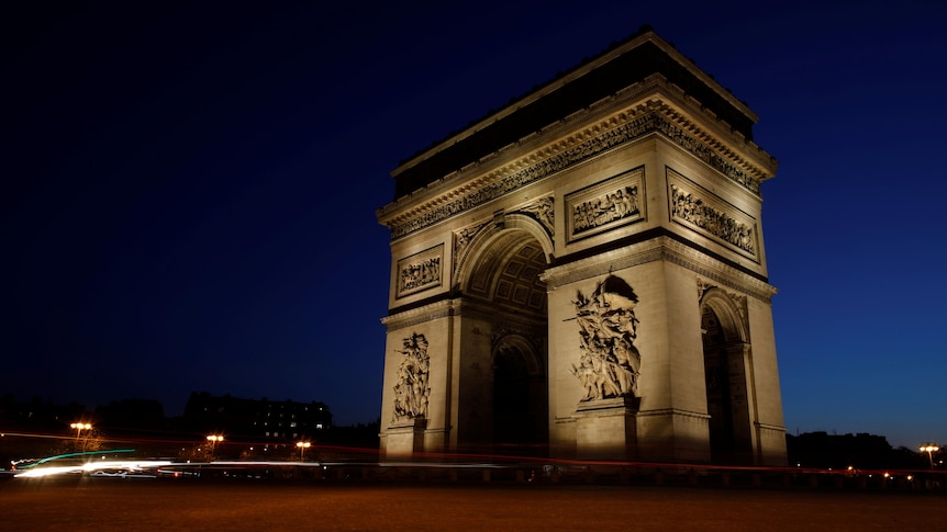 The Arc De Triomphe alight in front of a night sky 