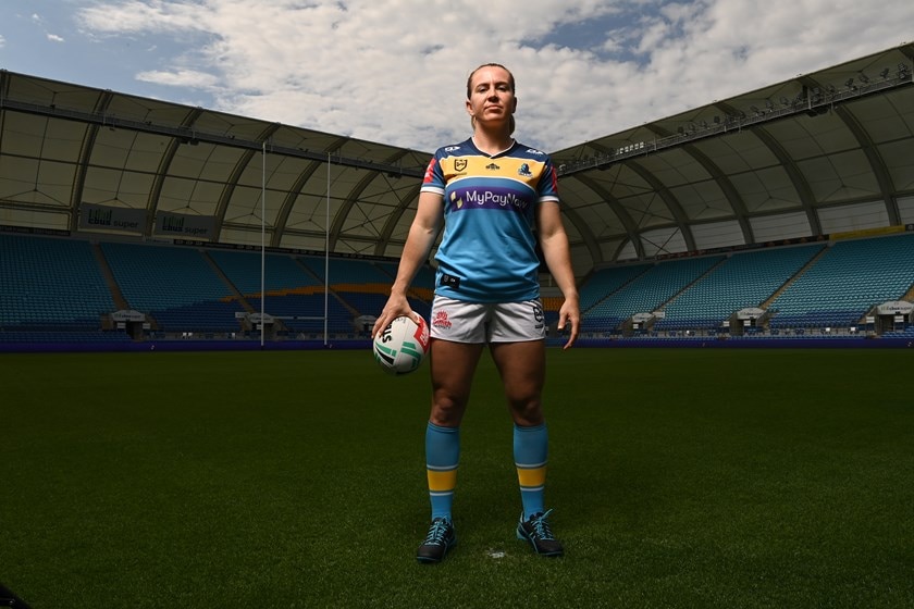 Georgia Hale stands on an empty football field with a football in her hand.