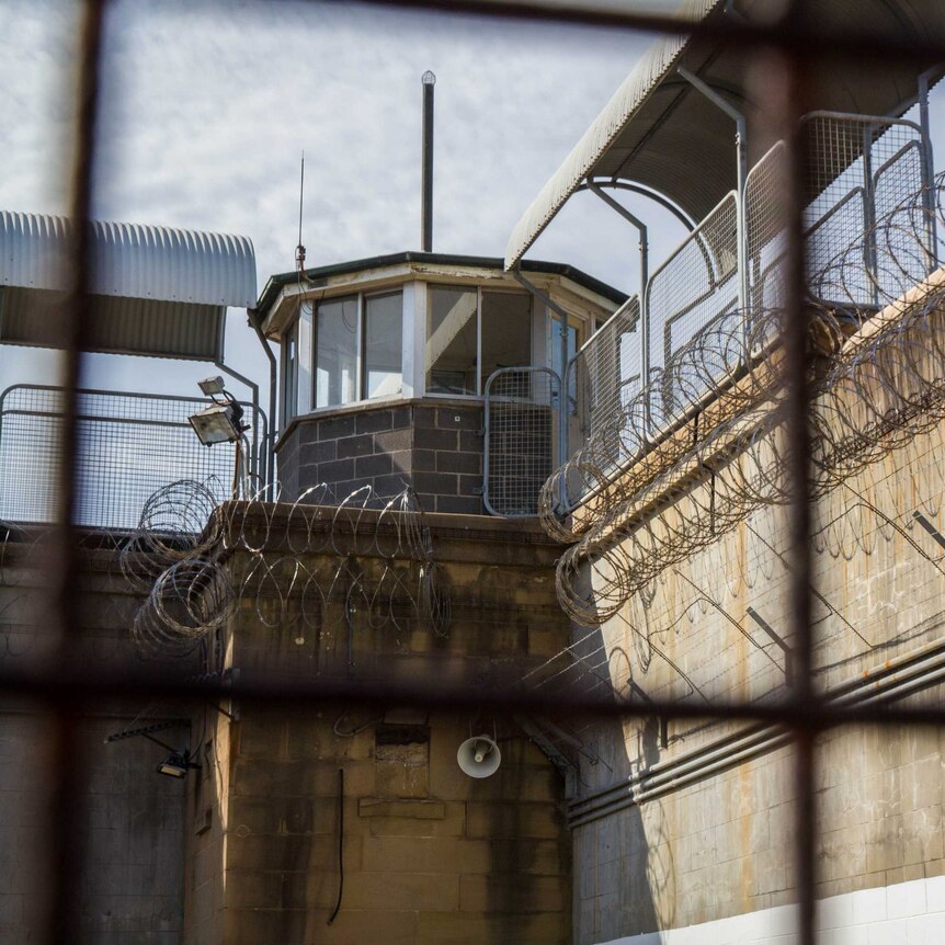 A prison watch tower as seen through a fence.