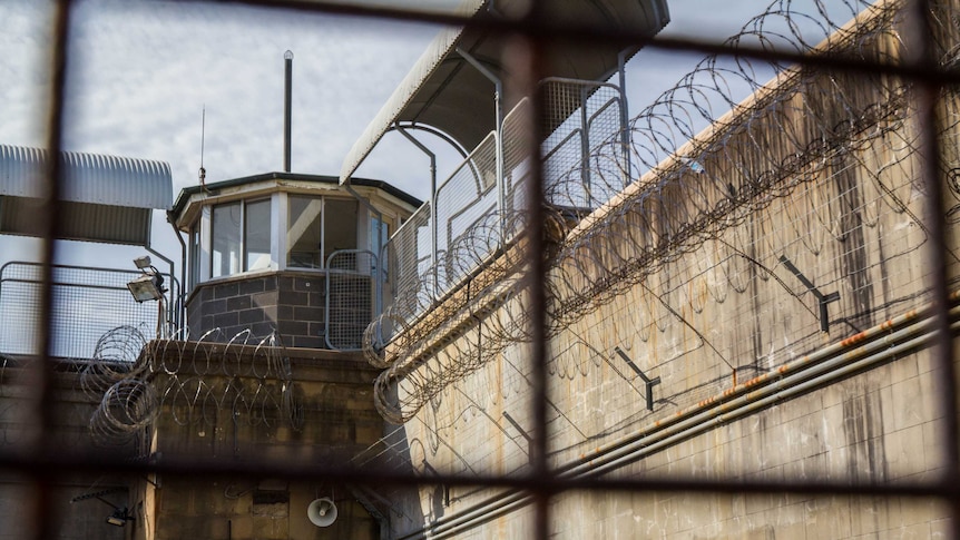 A prison watch tower as seen through a fence.