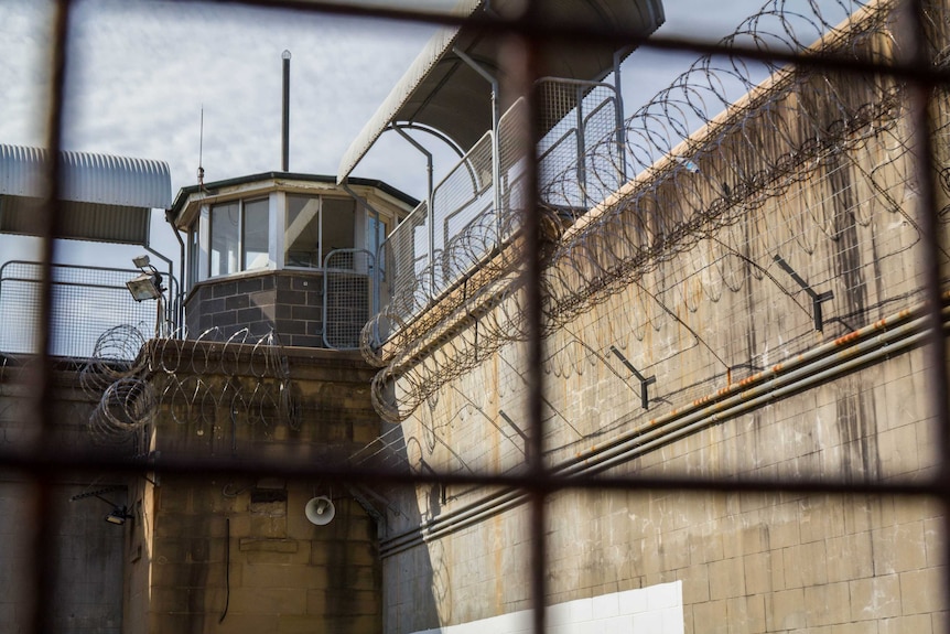 A prison watch tower as seen through a fence.