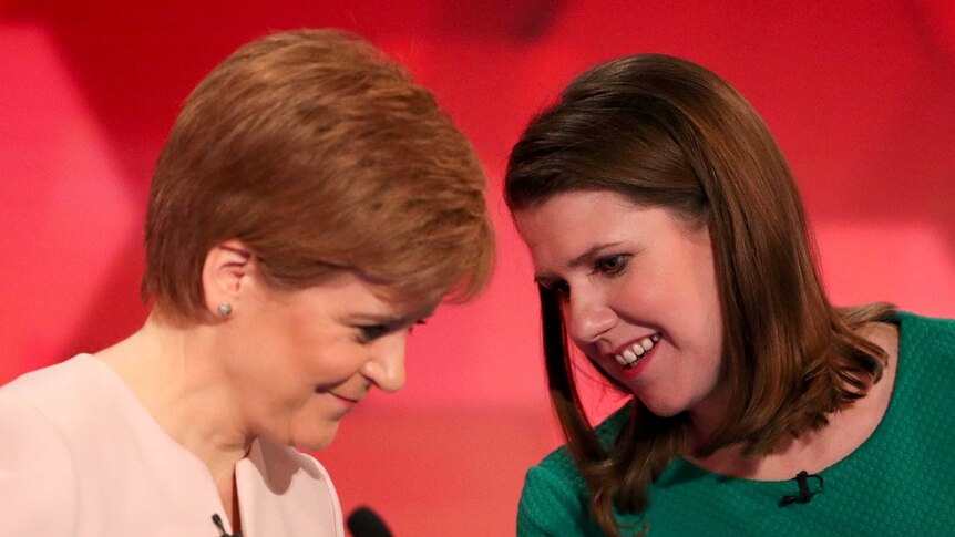 Nicola Sturgeon and Jo Swinson leaning towards each other and talking during a debate