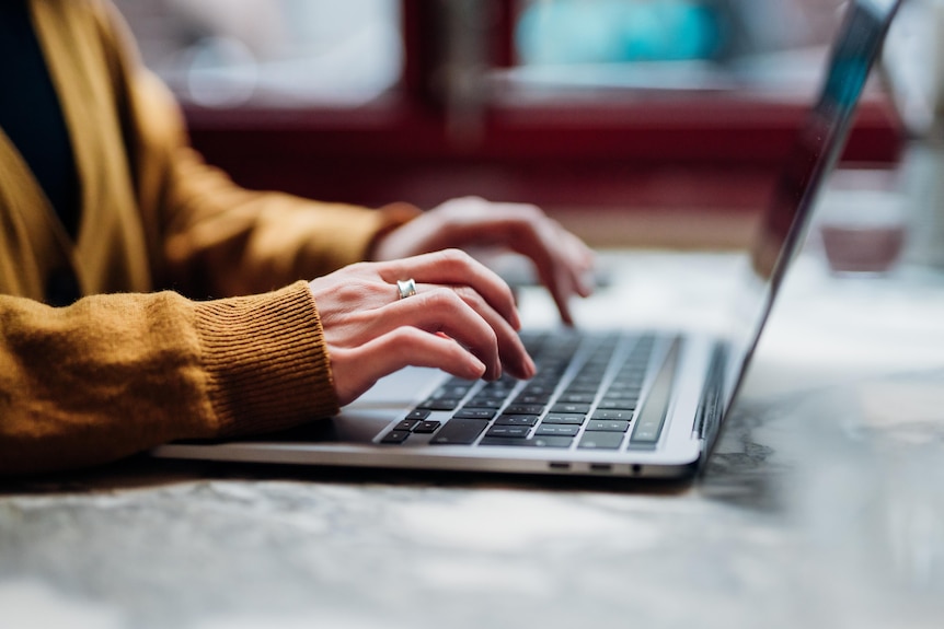 A photo of a woman's hands using a laptop