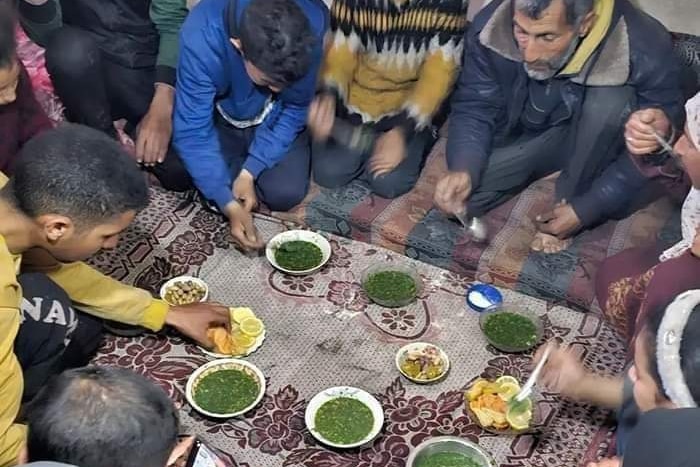 plates full of ground up grass and lemon are shown, and many shown kneeling on floor to eat it.