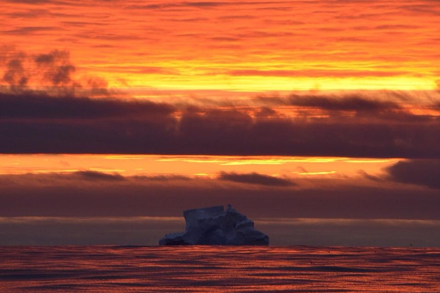Sunrise colours with iceberg.
