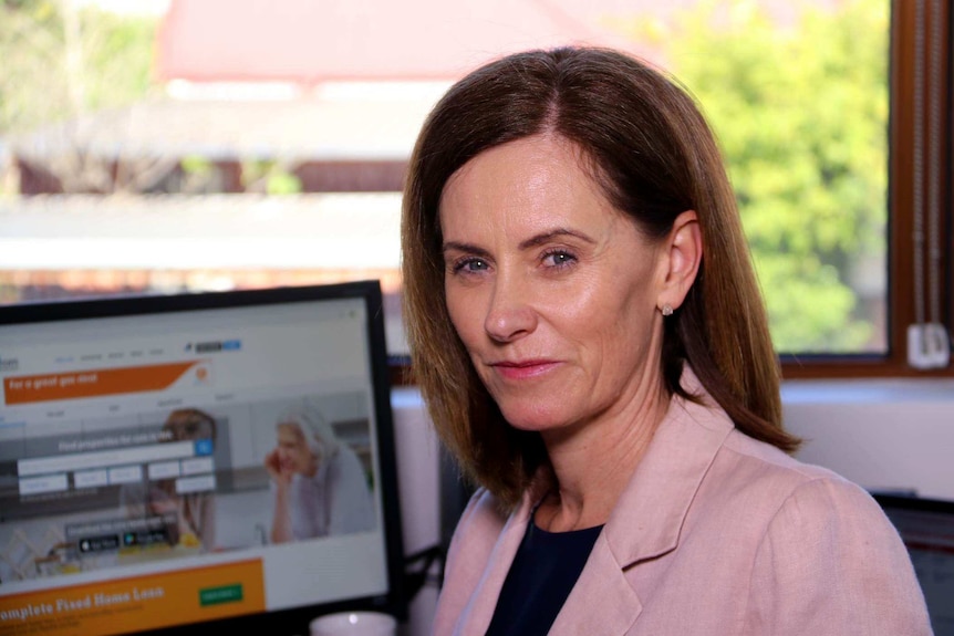 Headshot of a woman sitting at a computer.