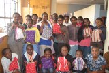 Girls at a Kenyan orphanage hold re-usable sanitary kits made in Tasmania in 2014.