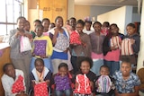 Girls at a Kenyan orphanage hold re-usable sanitary kits made in Tasmania in 2014.