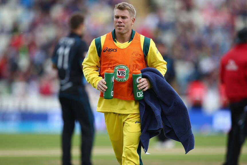 Different role ... David Warner takes on drinks duty against the Black Caps