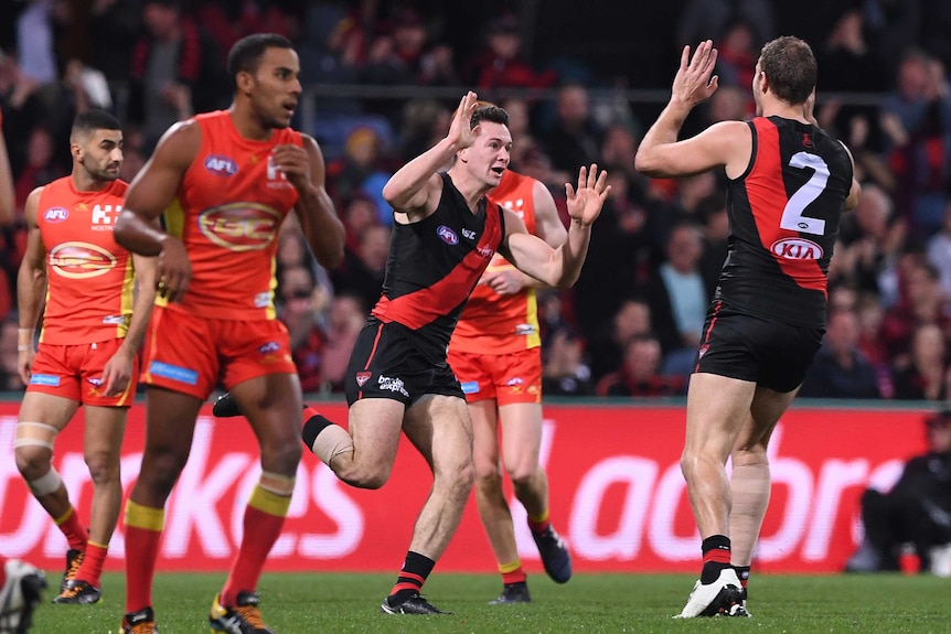 Conor McKenna celebrates his goal for Essendon against Gold Coast