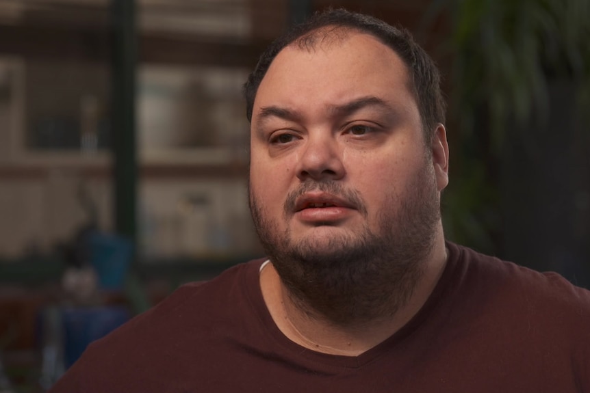 A man wearing a maroon t-shirt.