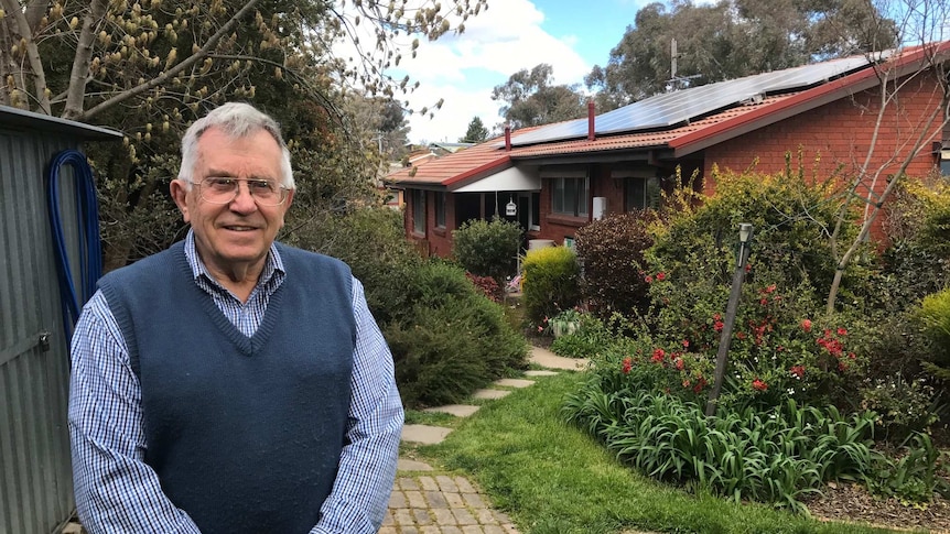 Eric Pulford in his backyard. The roof of his house is covered with solar panels.