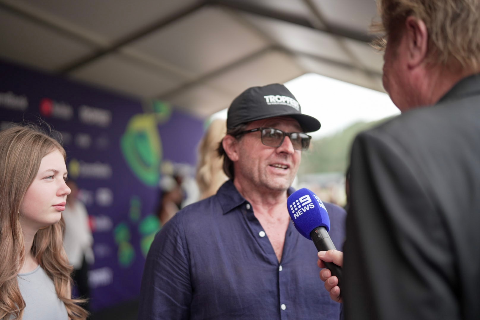 A man in sunglasses and a dark cap.