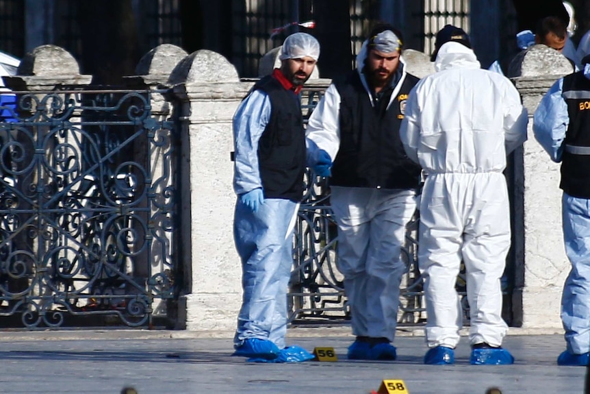 Police forensic officers survey the scene near the Blue mosque - not in view.