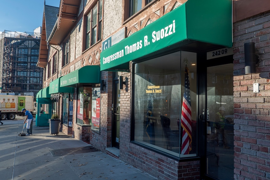 An office with an American flag in the window and a green awning that reads 'Congressman Thomas R. Suozzi'