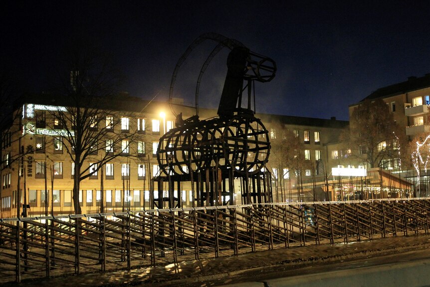 The charred frame of a giant straw goat, which was deliberately burned, stands bare in a fenced off area.