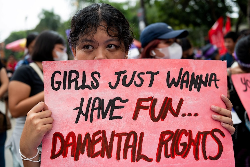 A Filipino activist holds a placard during a protest on Women's Day.