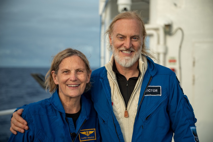 Kathy Sullivan and Victor Vescovo stand next to each other and smile on a boat