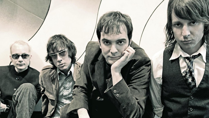 Black and white photo of the four members of Fountains of Wayne wearing suits