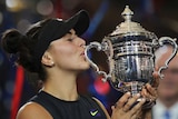 Head and shoulders shot of Bianca Andreescu kissing the trophy