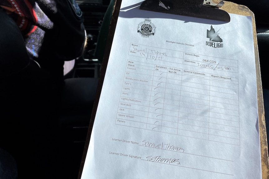 Clipboard with vehicle condition checklist signed by a student