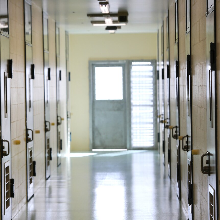 A corridor inside a jail with locked doors.