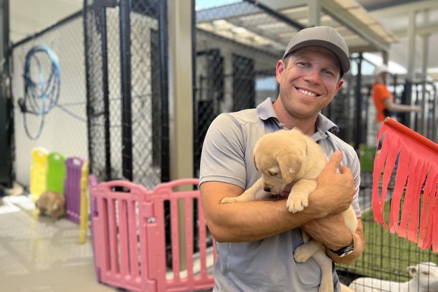 A man holding a labrador puppy