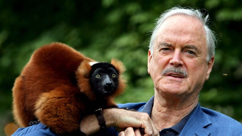 Actor John Cleese stands with his friend and co-star Colin, a red ruffed lemur