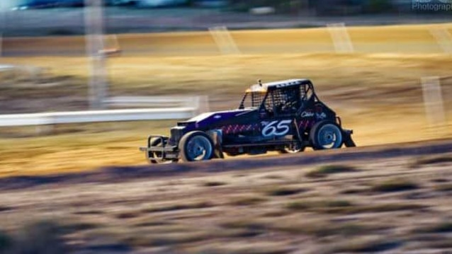 Racing car with number 65 on door in focus, background blurred