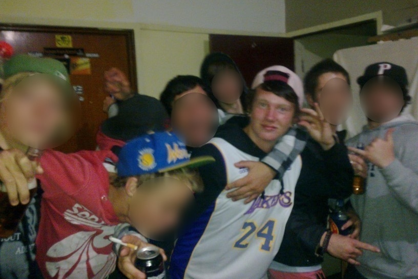 A group of teenage boys drinking together at a party.