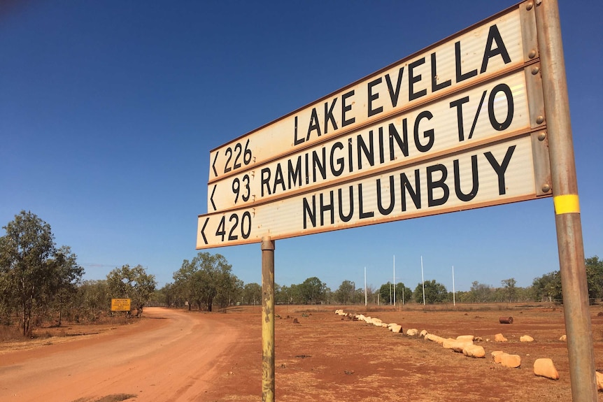 A photo of a road sign saying 420 kilometres to Nhulunbuy, by the side of a dusty highway