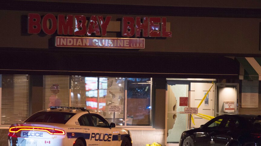 Police stand outside the Bombay Bhel restaurant