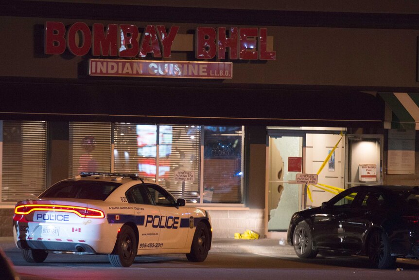 Police stand outside the Bombay Bhel restaurant