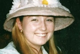 An archive photo of Sarah Spiers sitting at a restaurant table smiling and wearing a hat with flowers.