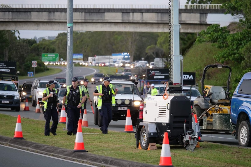 Police at the head of a long line of traffic on a highway