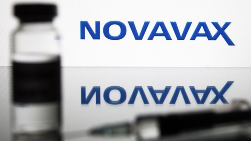 Illustration of a medical syringe and a vial with COVID-19 vaccine in front of the Novavax company logo.