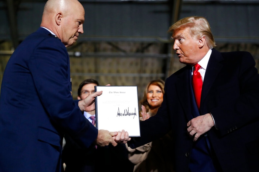 President Trump shakes hands with the chief of space operations at the launch of the Space Force.