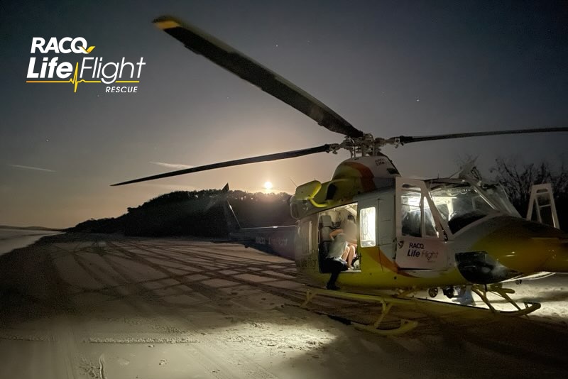 A picture of a rescue helicopter on a beach at sunset. 