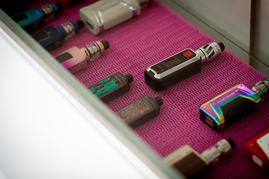 various refillable vaping devices on display on a pink placemat. 