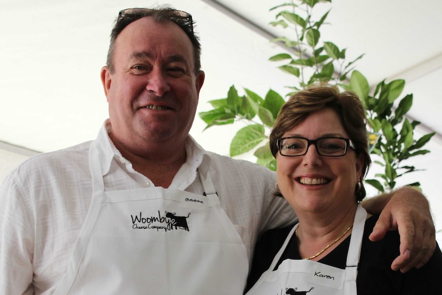 Graeme and Karen Paynter smile at the camera wearing their Woombye Cheese aprons.