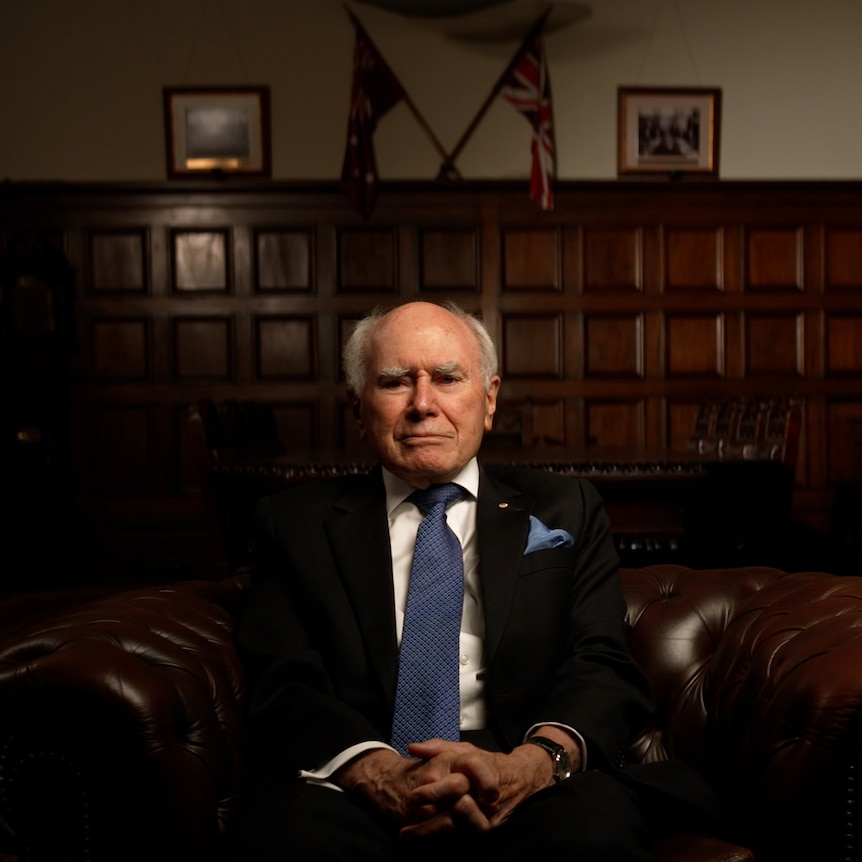 John Howard sits in a chair looking at the camera.