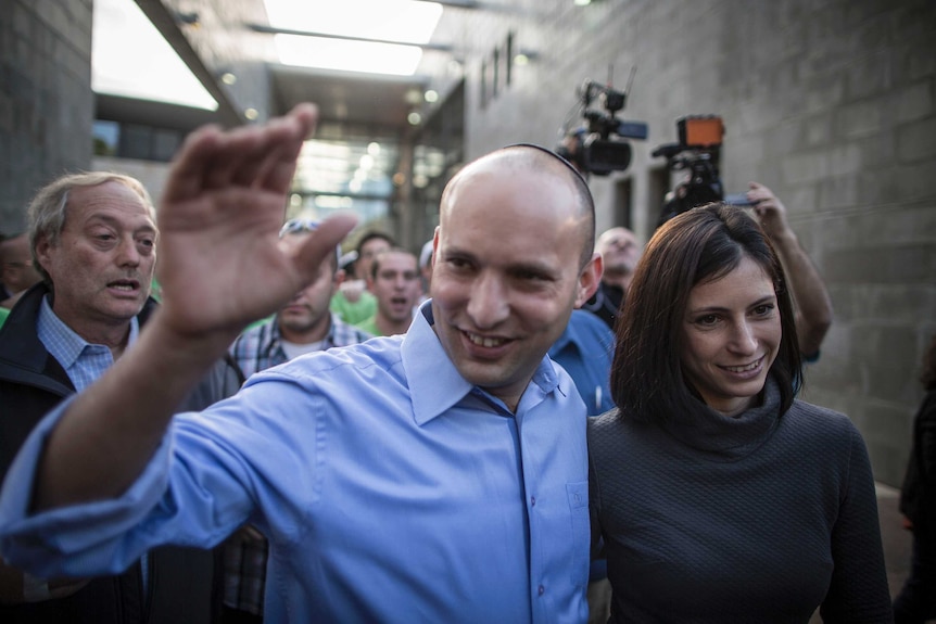 Bayit Yehudi (Jewish Home) party leader Naftali Bennett waves to supporters alongside his wife
