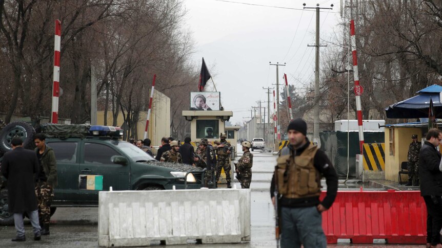 Security forces inspect the site of a suicide bombing in the diplomatic area of capital Kabul