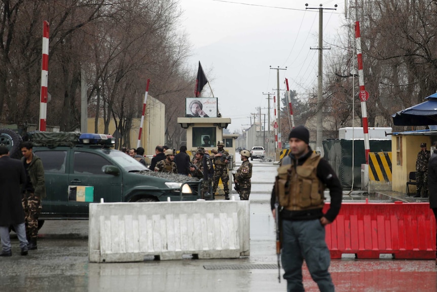 Security forces inspect the site of a suicide bombing in the diplomatic area of capital Kabul