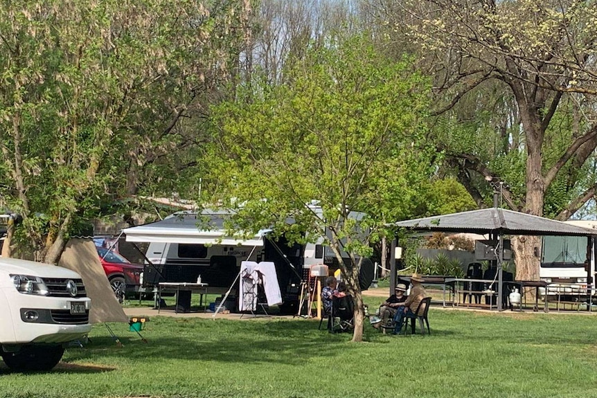 People camping at caravan park in green bushland