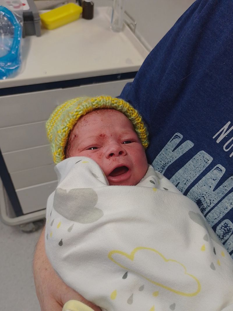 A baby in a little yellow beanie.