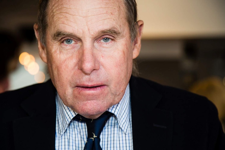 Close up of elderly man wearing a suit and tie.